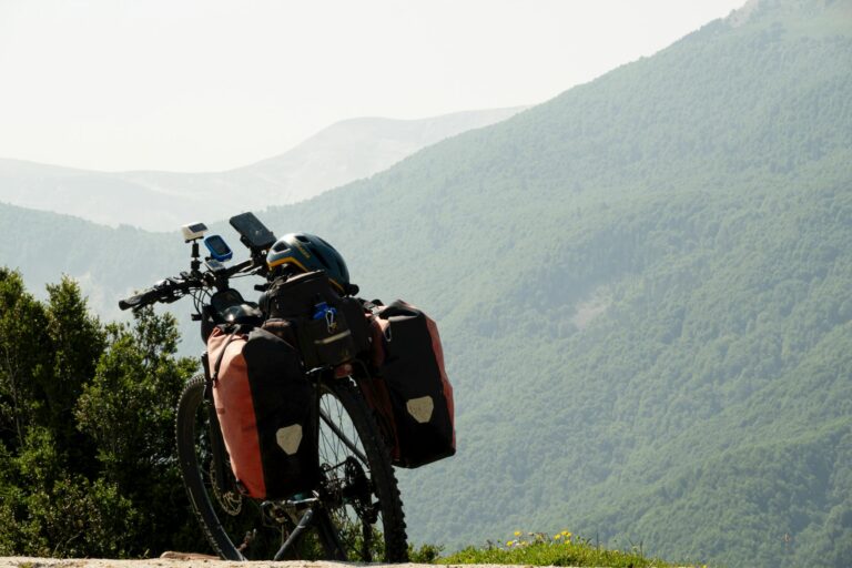 Mountain bike with gear on a trail, overlooking a breathtaking mountainous landscape, perfect for adventure seekers.